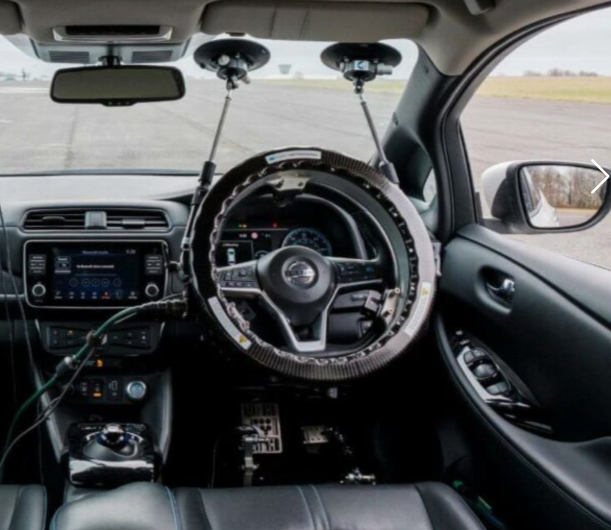 An existing steering robot held by a frame suction-cupped to the windshield