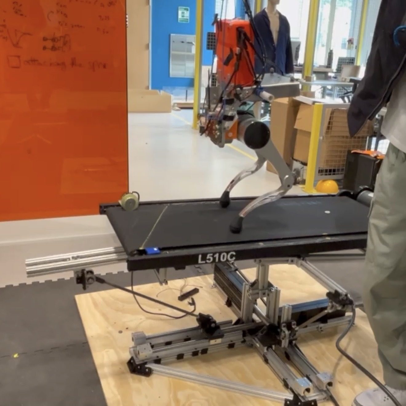 A biped robot walking on a treadmill mounted on the platform